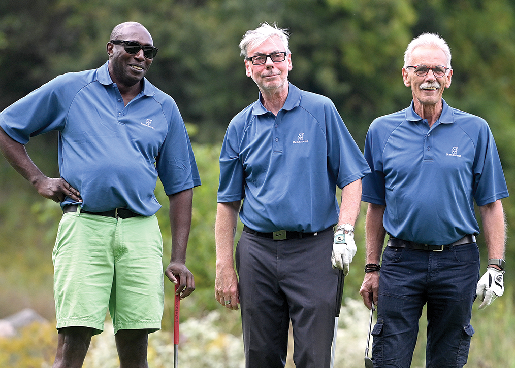 A photograph of three men on the course.
